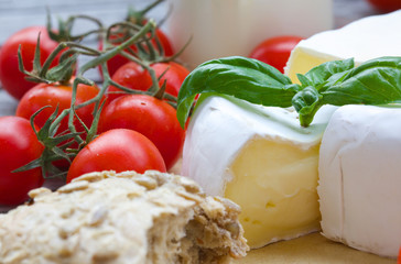 Stinky French cheese and red cherry tomatoes. Closeup