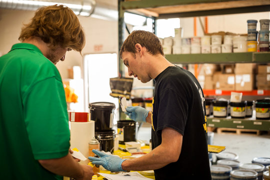 Workers checking inks in screen printing workshop