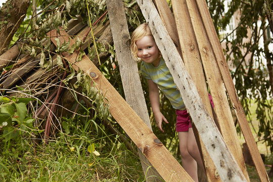 Portrait Of Girl Hiding In Garden Den