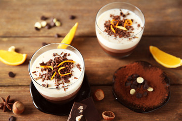 Layered desserts with decoration on wooden table