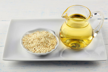 Sesame seeds and oil on wooden table