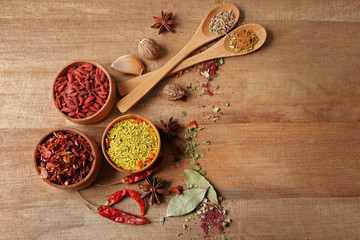 Assorted spices on wooden table, top view