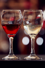 Glasses of red and white wine against blurred background