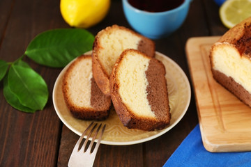 Delicious sweet cake bread with lemons on wooden table closeup