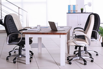 Modern office. Furniture set with table and chairs. Laptop on the table