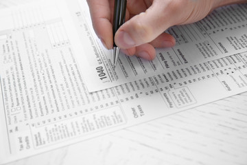 Man filling American form of Individual Income Tax Return at the table