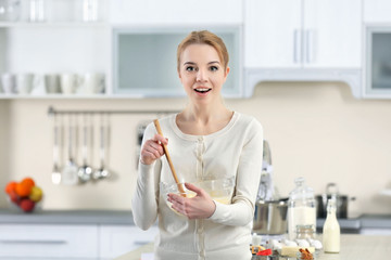 Young woman mixing dough in a bowl