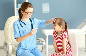 Fototapeta premium Doctor checking little girl's temperature