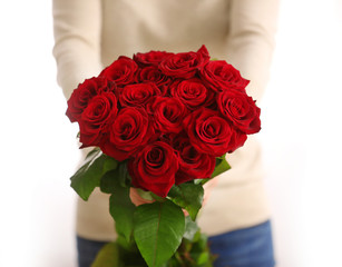 Woman with beautiful bouquet of red roses indoors