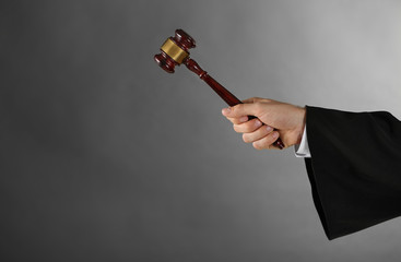 Judge hand with gavel on grey background