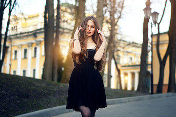 Fototapeta premium Attractive young sexy woman enjoying her time outside in park with sunset in background.