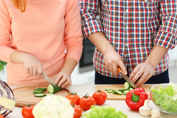 Happy couple cooking salad on the kitchen, close up