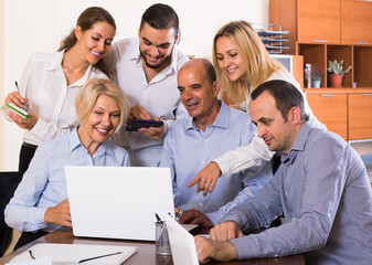 colleagues looking at laptop and smiling