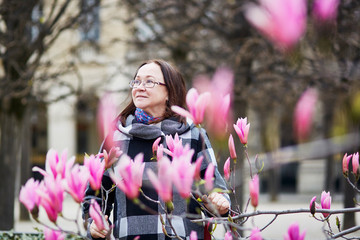 Beautiful middle aged admiring pink magnolia © Ekaterina Pokrovsky
