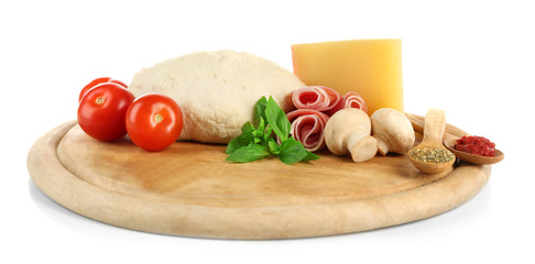 Fresh dough and other different ingredients for pizza on cutting board isolated on white