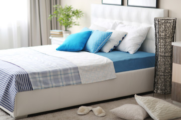 Bedroom interior in light tones with white furniture and pillows