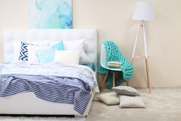 Bedroom interior in light tones with white furniture and pillows