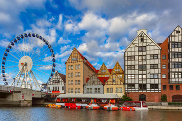 Ferris wheel with water reflection at Trade fair St Dominic in Old Town of Gdansk in the morning, Poland