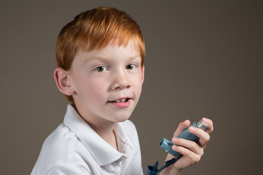 Young Boy With Asthma Holding An Inhaler