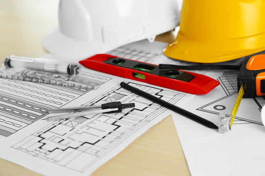 Construction drawings and other tools on wooden table closeup