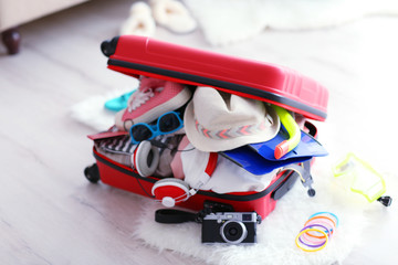 Open red suitcase on the floor, close up