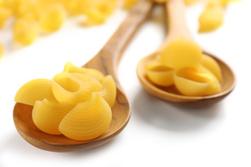 Italian dry pasta on wooden spoons, close up