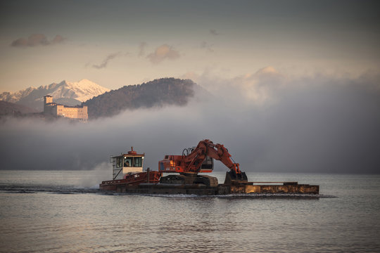 Excavator on barge,  Lake Maggiore, Varese, Piemonte, Italy