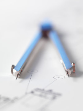 Dividers sitting on engineering drawing used in the measurement of design features