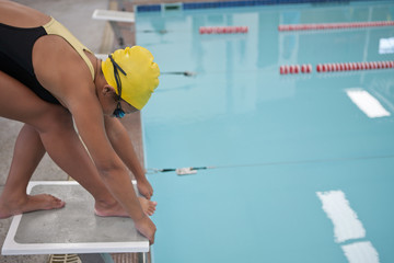 Girl training and preparing to jump into swimming pool