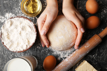 Female hands holding dough, top view
