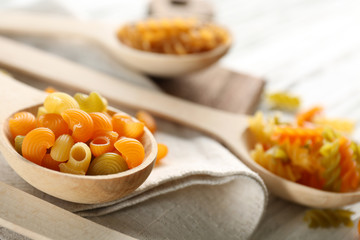 Different types of pasta in spoons napkin closeup