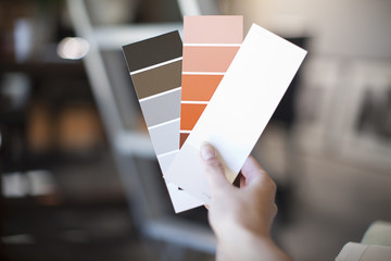 Close up of female hand holding up swatches