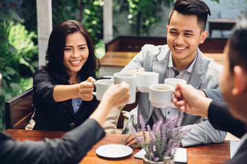 business Friends Cheering With Coffee at cafe