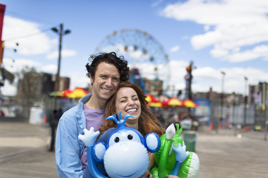 Portrait of couple and inflatable monkeys at amusement park