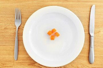 White plate with carrots  on wooden background