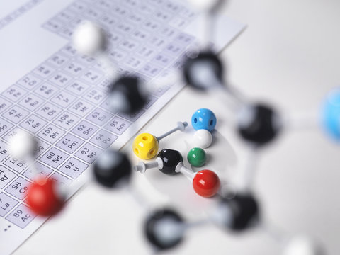 Molecular model next to periodic table on lab bench