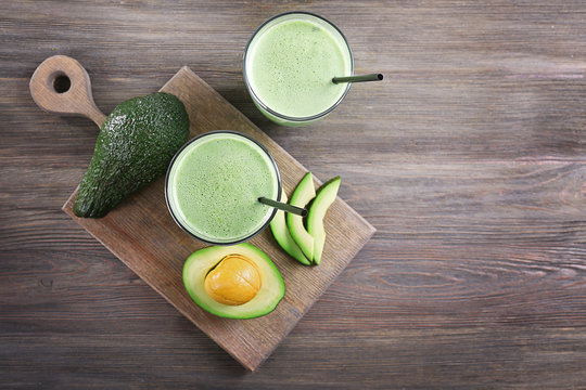 Avocado smoothie on wooden table, top view