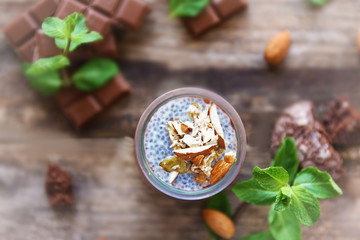 Chocolate chia seed pudding with crushed almonds on wooden table