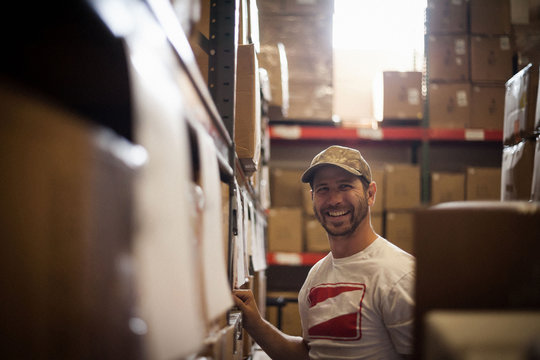 Worker and cardboard boxes stored in warehouse