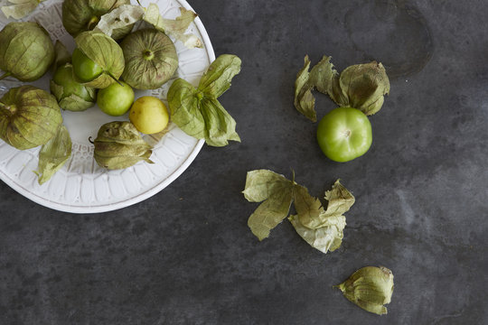 Fresh tomatillos on a plate and zinc metal surface