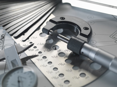 Engineering design -  micrometer, feeler gauge and screw gauge on blueprint
