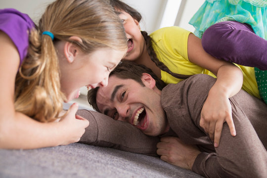 Girls tickling father
