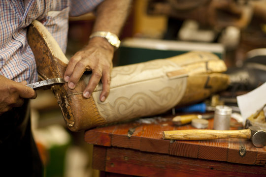 Cobbler mending sole of boot