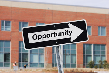 arrow sign with text opportunity in front of industrial building