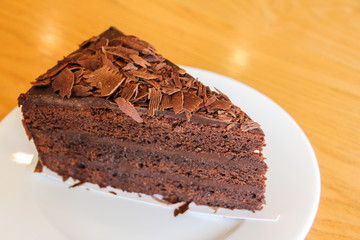 A piece of soft chocolate cake on white plate.