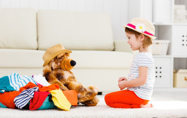 happy child girl collect suitcase on vacation