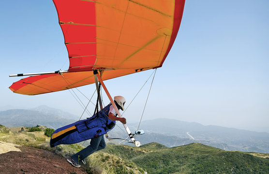 Hang glider pilot taking off
