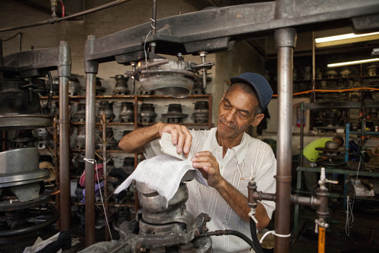 Hat maker measuring and chalking fabric in workshop