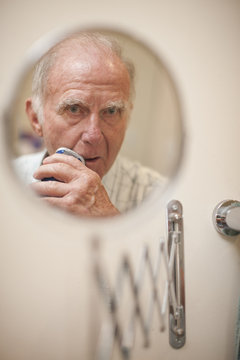 Portrait of senior man shaving 
