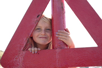 Portrait of girl looking through red triangle, Wales, UK
